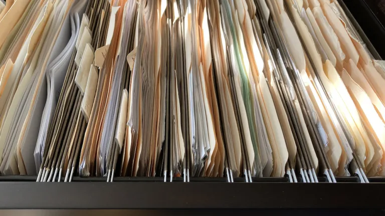 Open filing cabinet filled with documents.