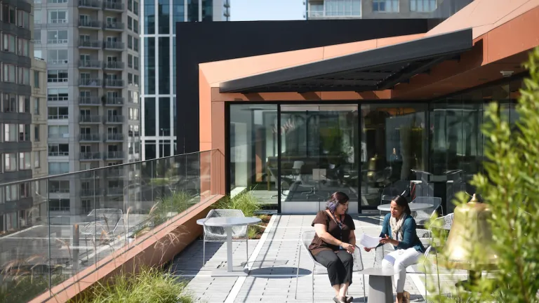 MTC employees meeting on the sunny landscaped patio, with a view of the East Cut neighborhood and the Bay Bridge.