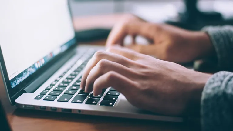 A person typing on a laptop computer.
