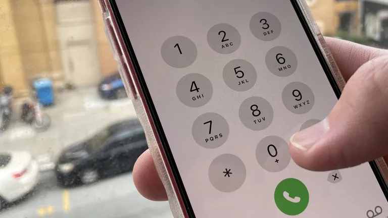 A man's hand holding a cell phone.