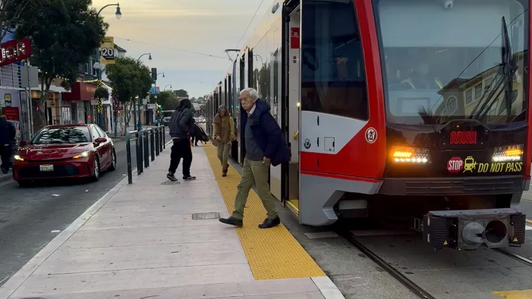 Passengers boarding and exiting the Muni K-Ingleside light rail train.