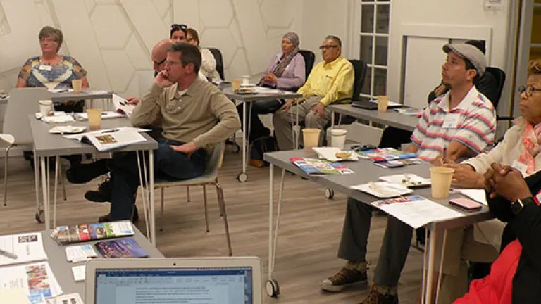 Room with individuals listening intently to a speaker out of view