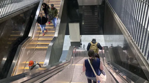 Transit travelers going up and down stairs at the Civic Center BART station in San Francisco.