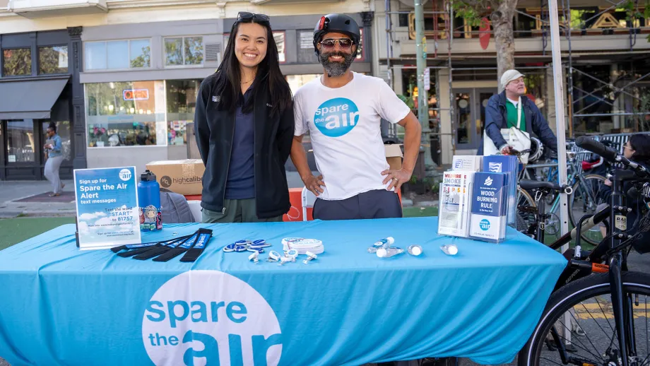 Two smiling people at a Spare the Air table on Bike to Work Day.
