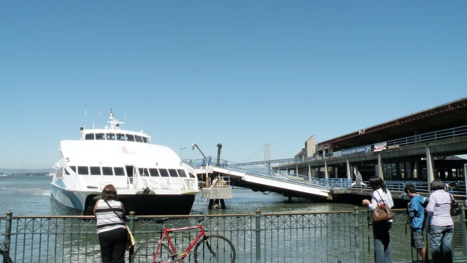 A cyclist looks out at a ferry boat at the San Francisco Ferry Terminal.