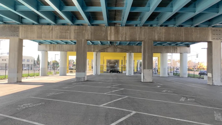 A view across the empty parking lot beneath I-880 at Fruitvale Avenue in Oakland