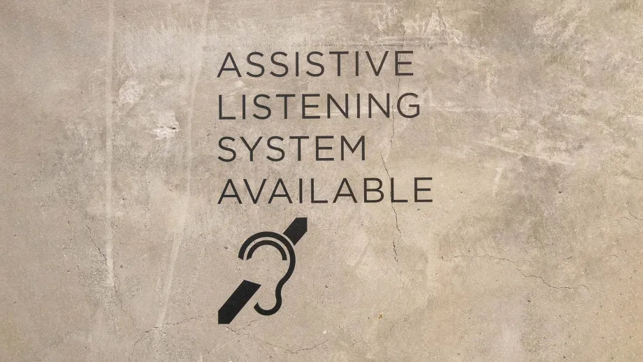 Sign indicating Assistive Listening System Available in a conference room at the Bay Area Metro Center.
